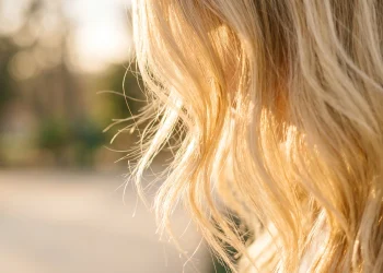 Detailed close-up of bright blonde hair strands in soft light.