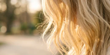 Detailed close-up of bright blonde hair strands in soft light.