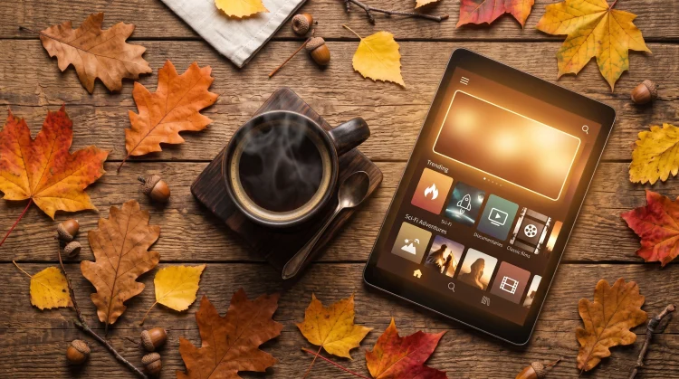 A cozy autumn setup with coffee and a tablet representing fall streaming content.