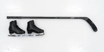 Figure skates and a hockey stick on ice representing the series .
