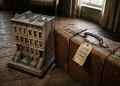 Conceptual image of an NYC apartment model and a suitcase with a London tag.