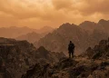 A desolate post-apocalyptic landscape under a hazy orange sky.