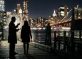 Silhouetted figures of two detectives standing against a New York City night skyline.