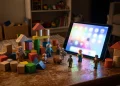 Conceptual image of traditional toys illuminated by a digital tablet screen.