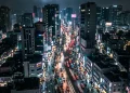 A cinematic conceptual view of a neon-lit urban street at night representing a modern city.