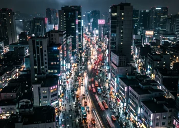 A cinematic conceptual view of a neon-lit urban street at night representing a modern city.