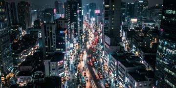 A cinematic conceptual view of a neon-lit urban street at night representing a modern city.
