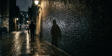 A conceptual atmospheric shot of a shadowy London alleyway.