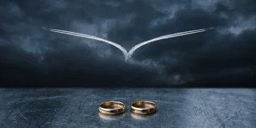 A conceptual image of a plane trail splitting and two wedding rings representing a double life.