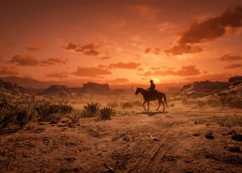 A silhouette of a lone cowboy in a vast desert landscape under a sunset sky.